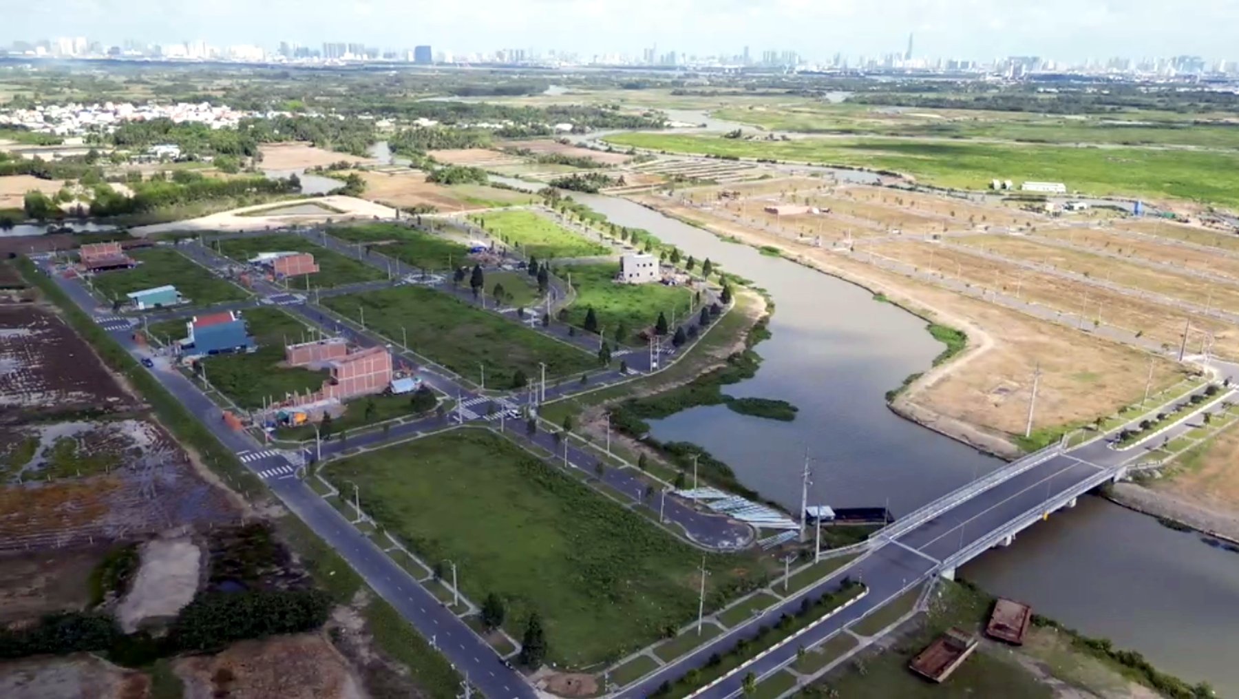 Toàn cảnh dự án — cầu và sông Gò Keo chạy giữa khu (ảnh flycam, không phải ảnh riêng của lô)
